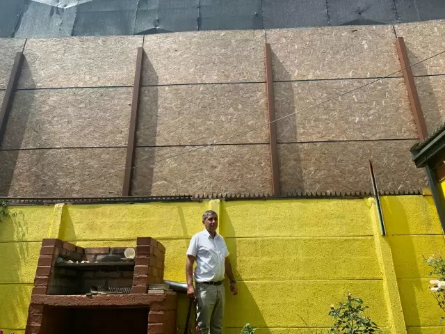 Uno de los vecinos, John Oviedo, muetra cómo quedarán de pegadas sus casas al edificio que tienen a 4 metros del patio. // Fotografía propiedad exclusiva de El Contraste.cl. © Todos los derechos reservados.
